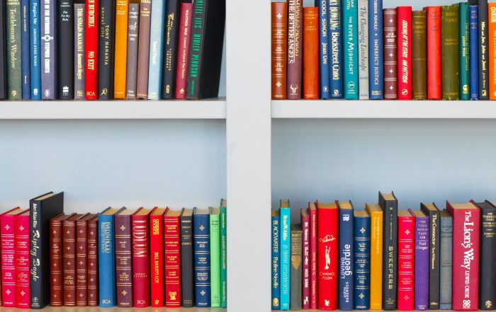 assorted-title book lot placed on white wooden shelf